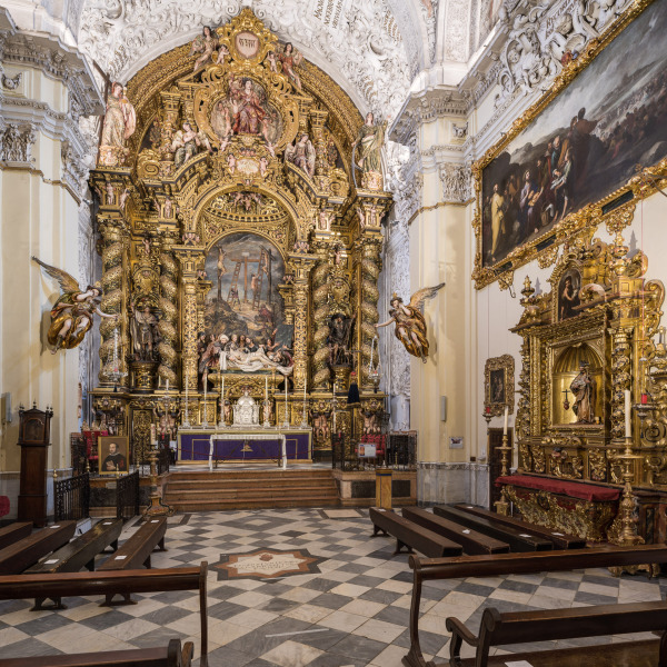 The Baroque-style church of Hospital de la Santa Caridad (Capilla de San Jorge) was promoted by Miguel de Mañara in Seville, Spain and completed in 1670.The high altarpiece of the Charity shows the relief of Christ’s descent (Valdés Leal) and the sculpture group (Pedro Roldán), while the altarpiece was made by Bernardo Simón de Pineda. At the right, the altarpiece of Saint Joseph (Bernardo Simon de Pineda) and above it, The Feeding of the Five Thousand (Bartolomé Esteban Murillo).