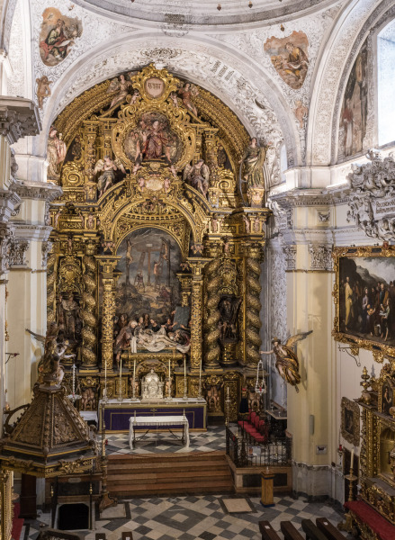 The Baroque-style church of Hospital de la Santa Caridad (Capilla de San Jorge) was promoted by Miguel de Mañara in Seville, Spain and completed in 1670.The high altarpiece of the Charity shows the relief of Christ’s descent (Valdés Leal) and the sculpture group (Pedro Roldán), while the altarpiece was made by Bernardo Simón de Pineda. At the right, below is the altarpiece of Saint Joseph (Bernardo Simon de Pineda) and above it, The Feeding of the Five Thousand (Bartolomé Esteban Murillo).